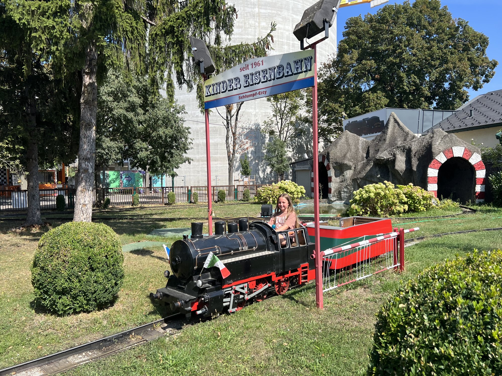 Ein Mädchen fährt in einer Kindereisenbahn.